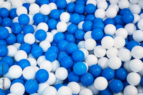 Lot of blue and white plastic balls in playroom.