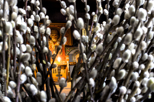 orthodox icons with a burning candle on the cross, a front blurred background of willows