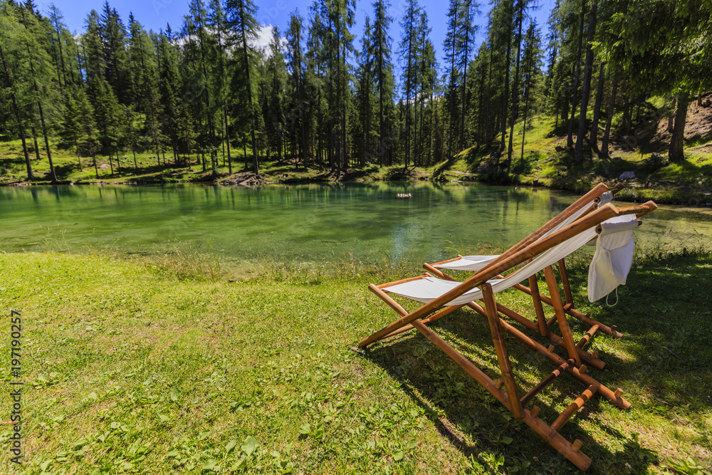 Pair of white chair on beach of relaxing lake at sunny day, Lago Ghedina