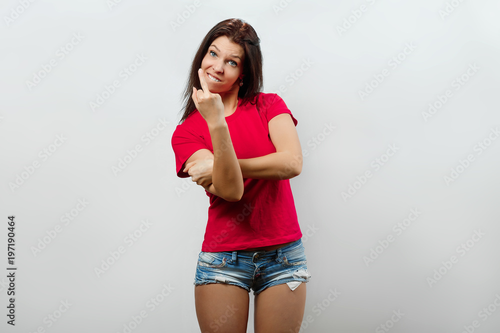 Fototapeta premium Young, beautiful girl showing the middle finger. Isolated on a light background. Different human emotions, feelings of facial expression, attitude, perception, body language, reaction.