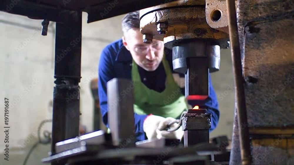 Making the knife out of metal at the forge. Man using pneumatic hammer to shape hot metal Making the knife out of metal at the forge. Man using pneumatic hammer to shape hot metal