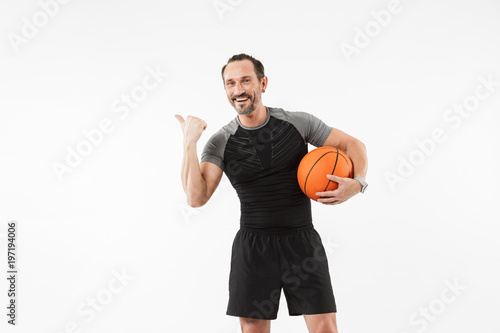 Portrait of a smiling mature sportsman holding basketball
