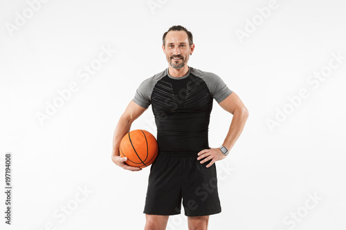 Portrait of a smiling mature sportsman holding basketball