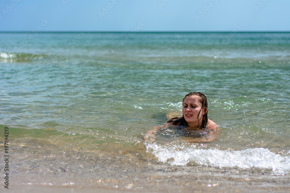 A young woman sails on the waves of the Black Sea