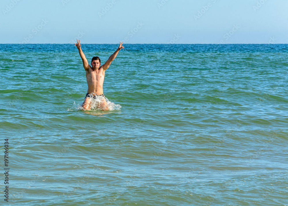 A sports man jumping over the sea waves in the black sea
