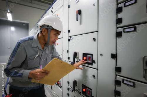 Young technician make a visual checking status switchgear electrical energy distribution substation 