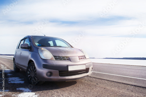 in a beautiful sunny day beige car parked at the side of the highway