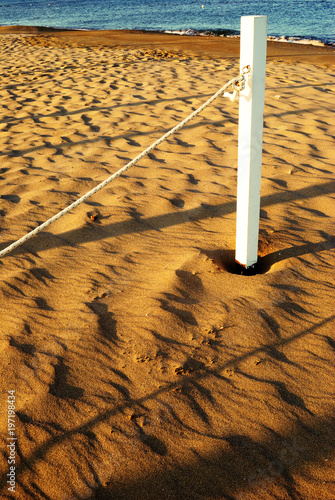 summer sea, white pole with rope on the beach at dawn © sonia62