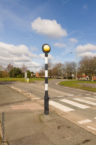 British Belisha beacon an amber flashing light on a black and white pole marking pedestrian crossings in the United Kingdom photo