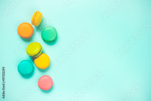 Colorful macaroons arranged over blue background. Copy space. Vintage effect.