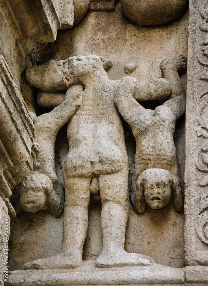 Sinners suffering in hell. Architectural detail. Facade of the church of St. Trophime in Arles, Provence, France.