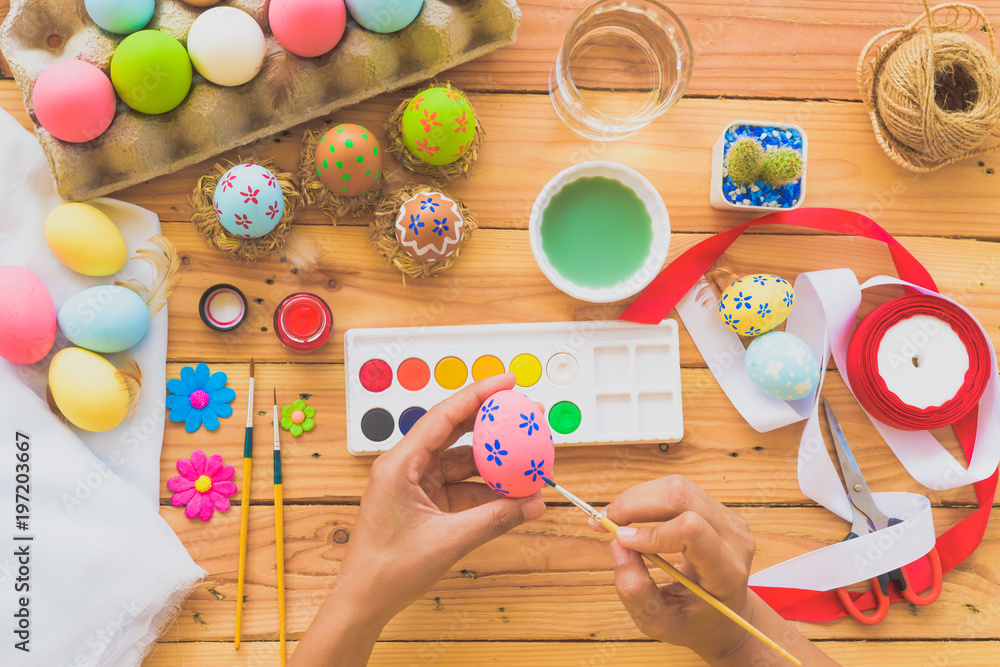 Happy easter! A woman hand painting Easter eggs. Happy family preparing for Easter.