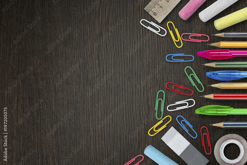 Colorful pencils, pens, stationery supplies on wooden background