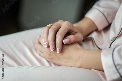 bride with beautiful manicure in a robe sits near the window,woman getting ready before wedding ceremony