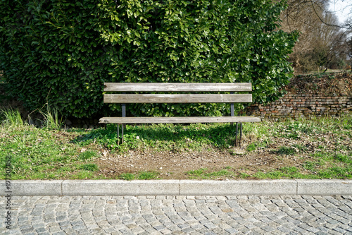 One wooden bench on sunny day in Italy, public parkland