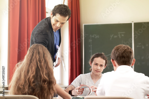 Lehrer oder Dozent steht im Unterricht vor einer Tafel und unterrichtet die Schüler in einer Klasse oder Schule