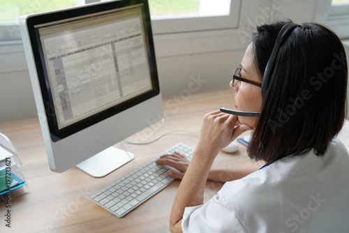 Medical secretary typing report on deskop computer