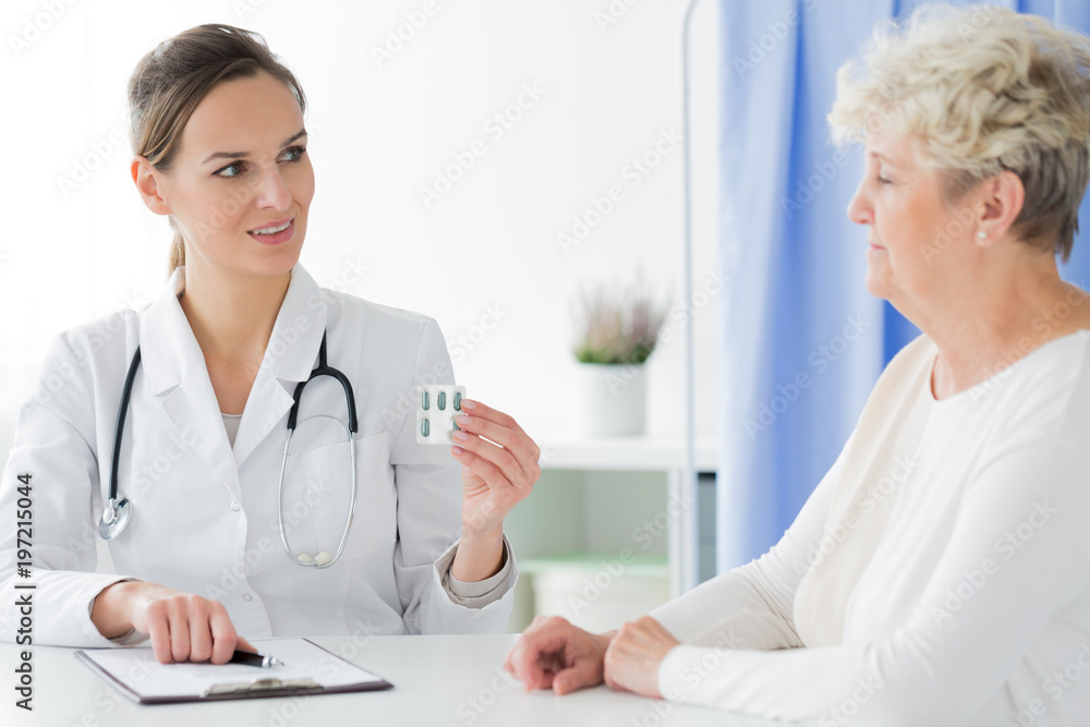 Doctor with stethoscope giving pills Doctor with stethoscope giving pills