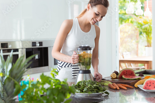 Smiling vegan woman making smoothie