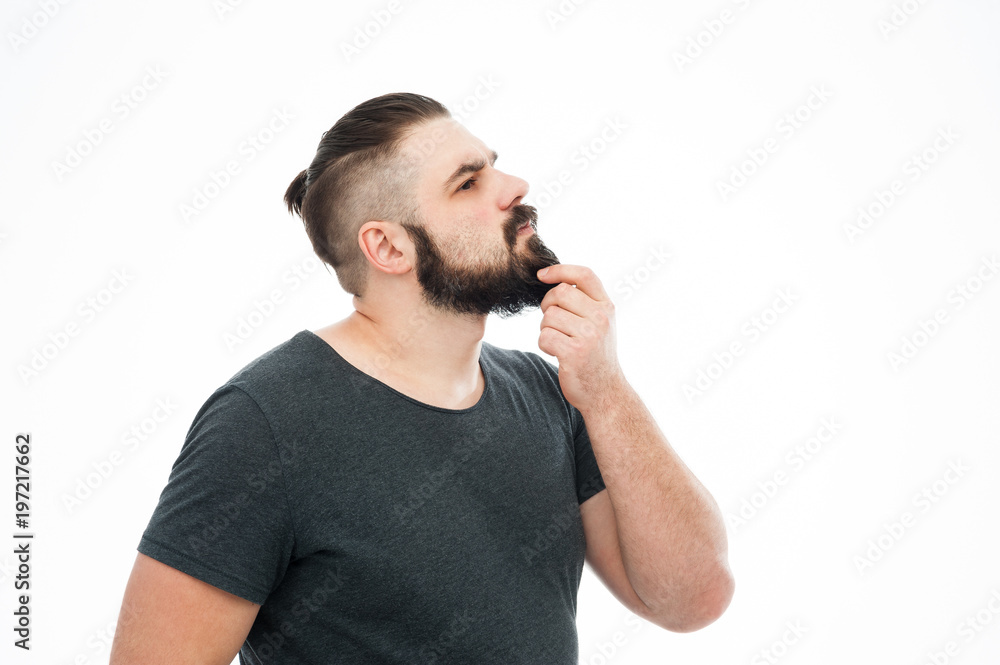 Portrait of a concentrated bearded man in plaid shirt carrying backpack and looking far away isolated over white background Portrait of a concentrated bearded man in plaid shirt carrying backpack and looking far away isolated over white background