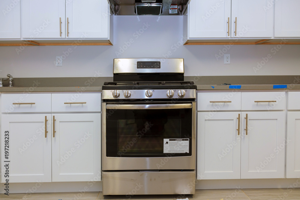 Fototapeta premium Installation of kitchen installs kitchen cabinet. Interior design construction kitchen