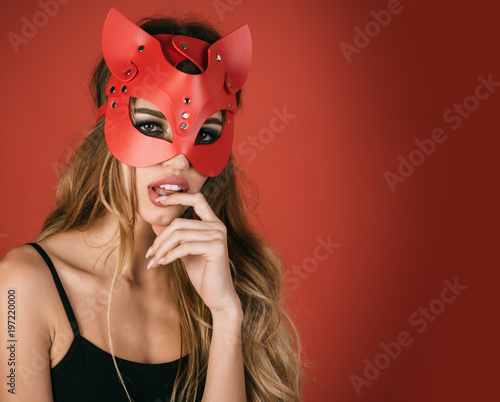 Glamor fashion sexy woman in cat mask. Isolated on red background. Christmas masquerade party, carnival, New Year, halloween concept - sexy portrait of woman wearing cat mask.