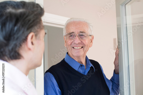 Man Checking On Elderly Male Neighbor photo