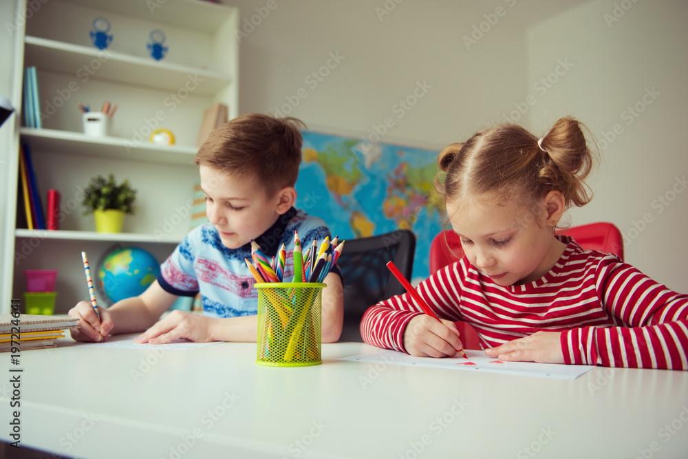 Two cute children drawing with colorful pencils Two cute children drawing with colorful pencils