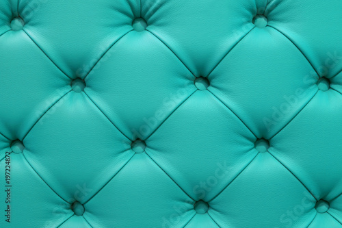Turquoise leather sofa stitched buttons.