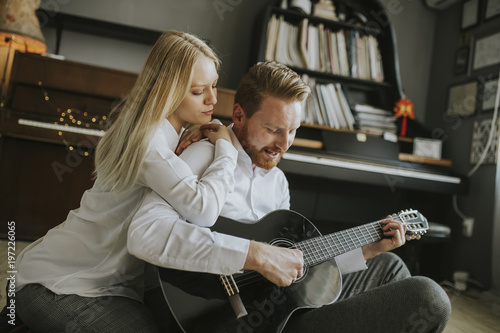 Young couple playing guitar...