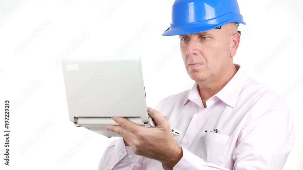Engineer Working Using a Laptop Accessing on Line Technical Information Engineer Working Using a Laptop Accessing on Line Technical Information