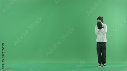 Little boy showing the forecast of cold and hot weather on the right side on the green screen