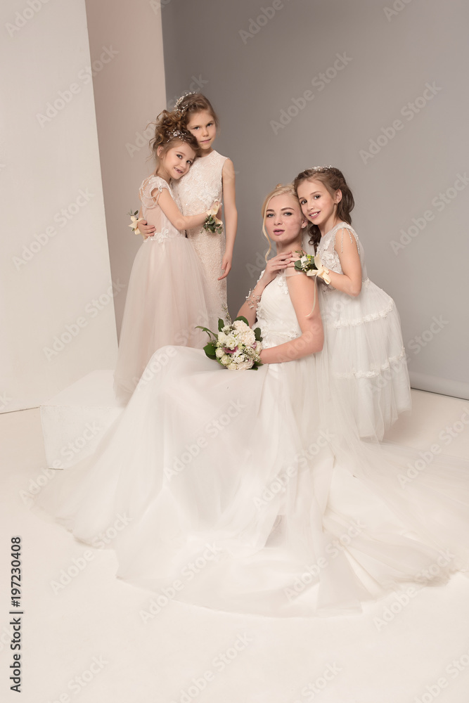 Little pretty girls with flowers dressed in wedding dresses Little pretty girls with flowers dressed in wedding dresses