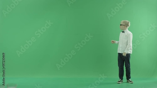 Little boy showing the forecast of hot and rainy weather on the right side on the green screen
