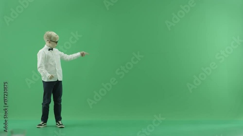 Little boy showing the forecast of hot and rainy weather on the left side on the green screen