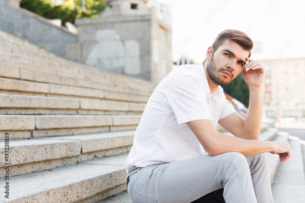 Thoughtful young man sitting outdoors