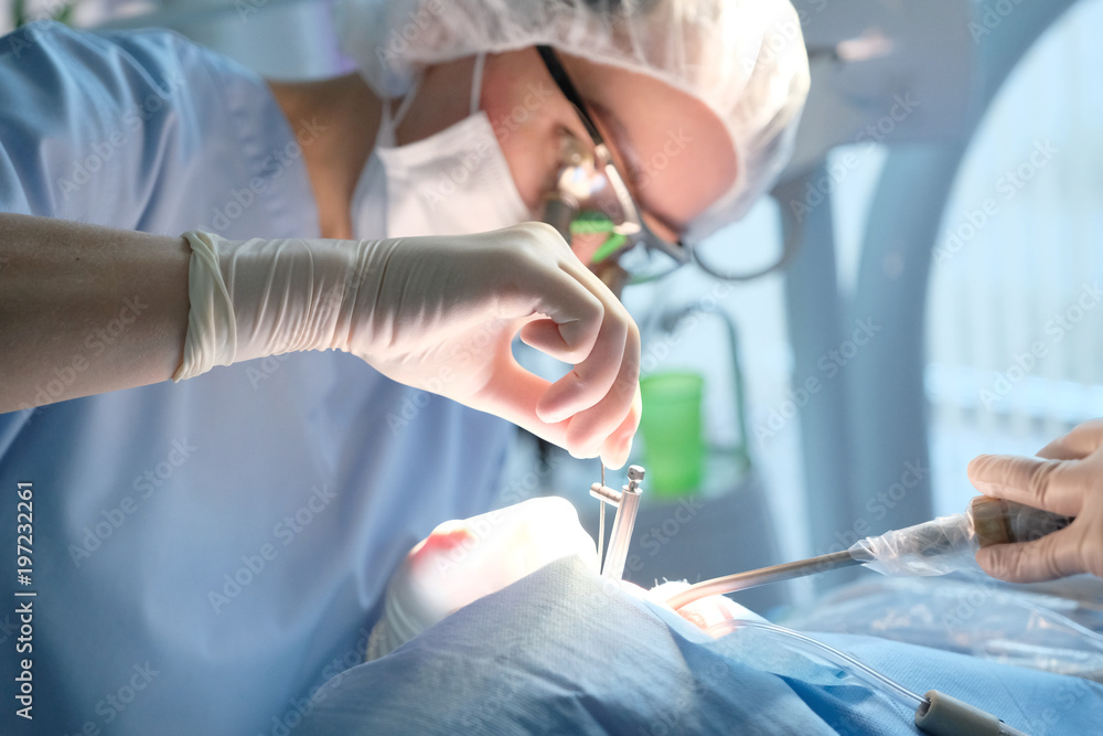 Doctor in uniform when performing a surgical dental surgery in the clinic Doctor in uniform when performing a surgical dental surgery in the clinic