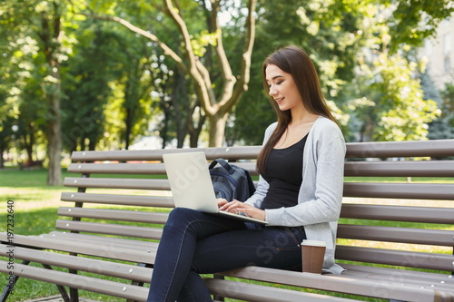 Happy young woman with laptop outdoors