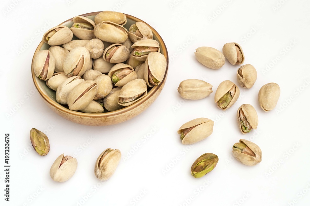 pistachio nuts on white background in a bowl pistachio nuts on white background in a bowl