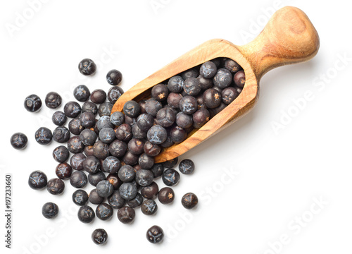 dried juniper berries in the olive wooden scoop, top view photo