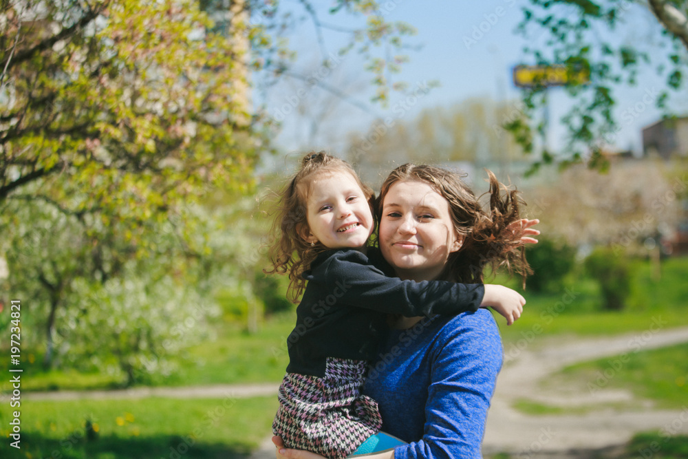 Fototapeta premium The girl hugs Mom. The child is in the mother's arms.
