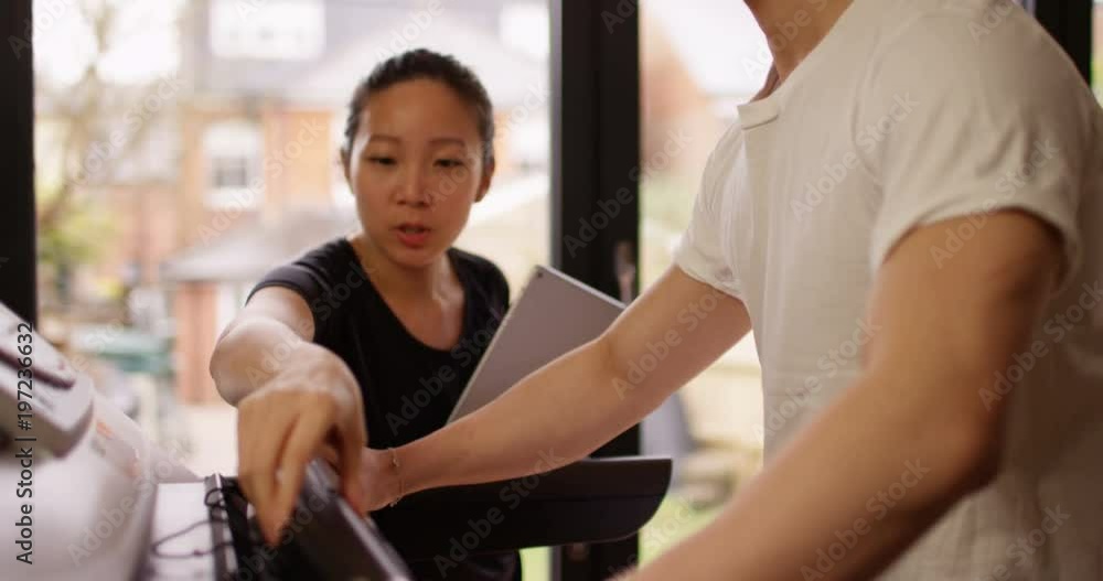 4K Female fitness instructor adjusting treadmill settings for her client at the gym. Slow motion. 4K Female fitness instructor adjusting treadmill settings for her client at the gym. Slow motion.