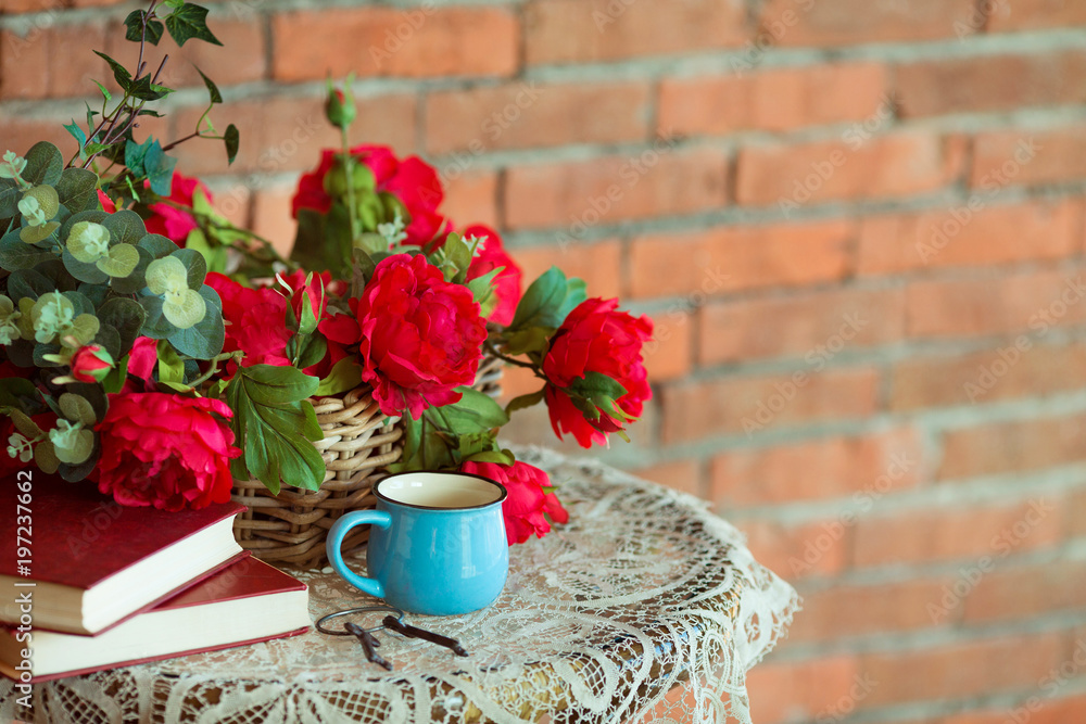 composition of red flowers on a table on a brick wall background