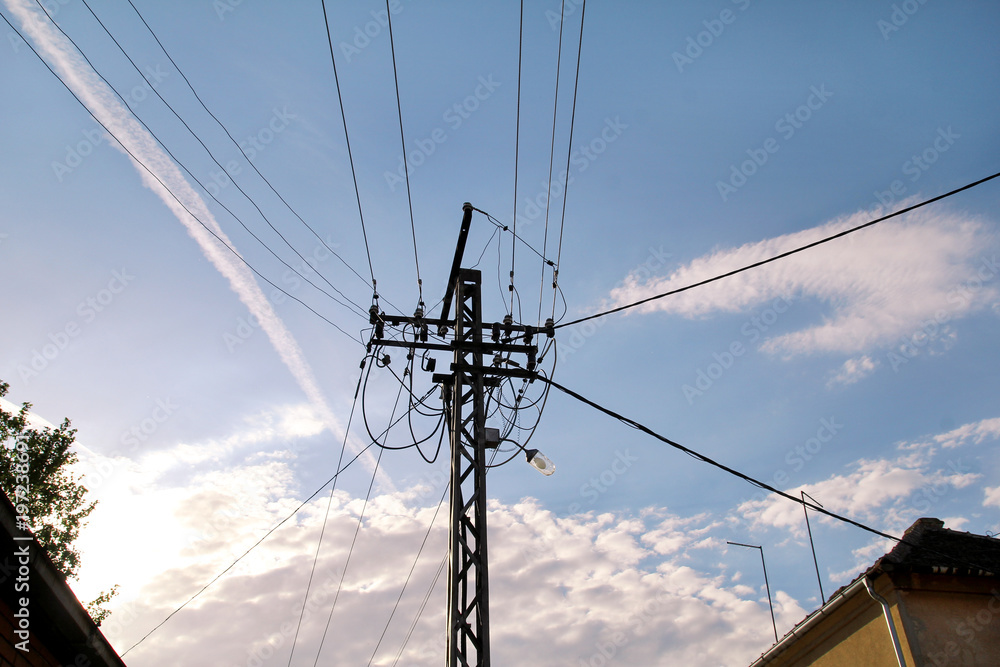 Old Power line electrical wire pillar with street feline lights against the blue sky / Wooden pole of power lines / A wooden pillar / Electricity Industry and Infrastructure. Old Power line electrical wire pillar with street feline lights against the blue sky / Wooden pole of power lines / A wooden pillar / Electricity Industry and Infrastructure.