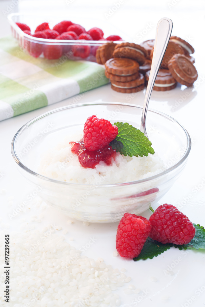 Milk Rice porridge with raspberry, white background light key Milk Rice porridge with raspberry, white background light key