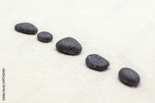 Five volcanic lava stones on white cotton towel.