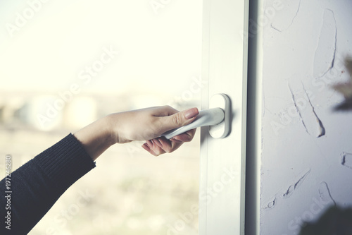woman hand opens a window