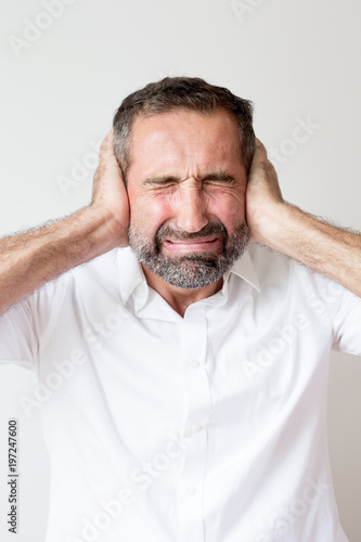 handsome man covering up his ears in pain