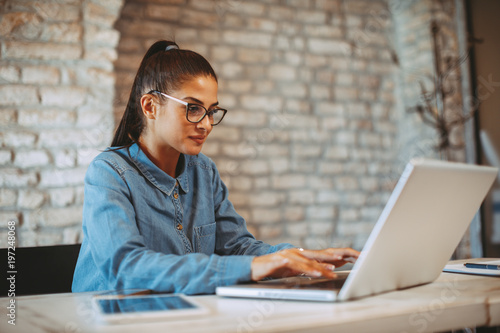 Canvas Print Young woman working on laptop in the office