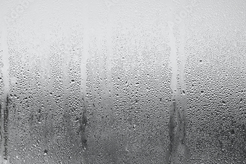 Background of natural water condensation, window glass with high air strong humidity, large drops drip. Collecting and streaming down